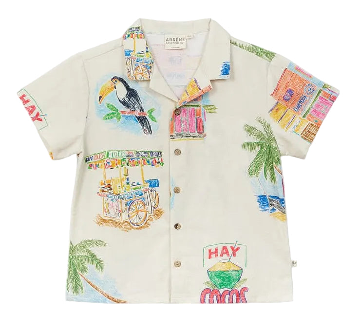 The Boys' Magnum Shirt by Arsene & Les Pipelettes is a short-sleeve, button-up cotton shirt featuring vibrant prints of toucans, palm trees, fruit stands, and playful "HAY" and "COCOS" signs on a light background. It’s designed in a relaxed fit to keep boys comfortable all day long.