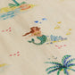 The Kids' Federico Shirt by Arsene & Les Pipelettes features a whimsical cream fabric with green-tailed mermaids, fish, coral, palm trees, and sandy islands—ideal for making a fun statement.