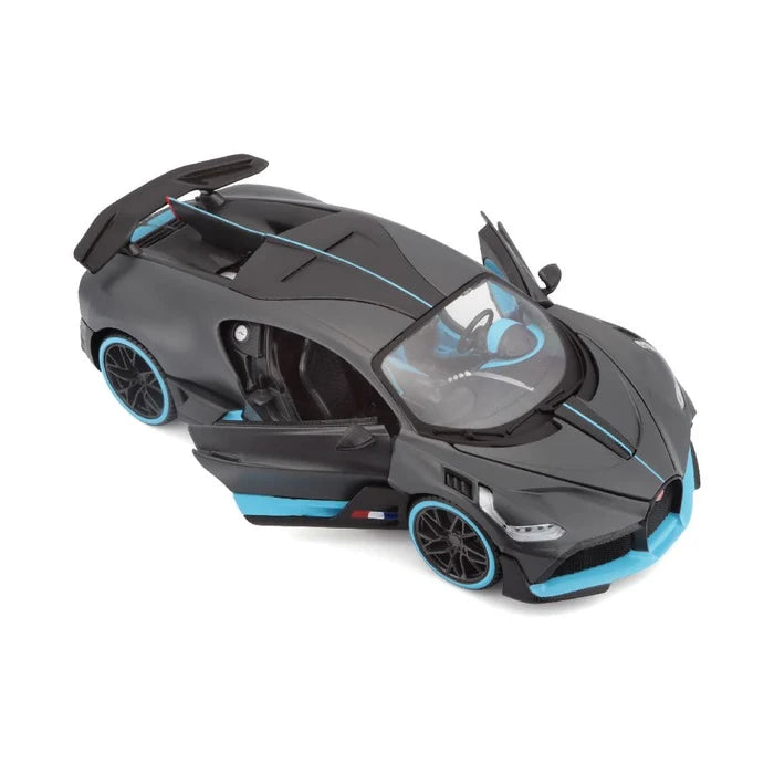 A 1:24 SE Bugatti Divo diecast sports car by Maisto, finished in matte black and blue, is shown from an angled overhead view with both driver and passenger side doors open.
