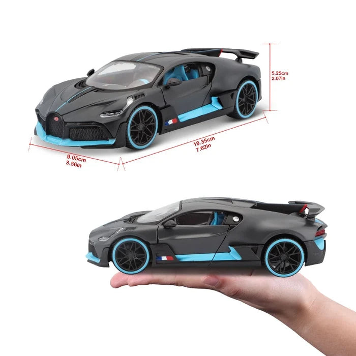 A 1:24 SE Bugatti Divo by Maisto, featuring a gray and blue color scheme, is displayed with measurements and shown on a person’s hand for scale to highlight the detailed design of this diecast sports car model.