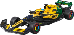 A yellow and black Maisto R/C 1:24 McLaren MCL38 (2024) - #81 toy car featuring green, red, and blue accents, inspired by Oscar Piastri’s Formula 1 vehicle, is displayed from a front-side angle on a white background.
