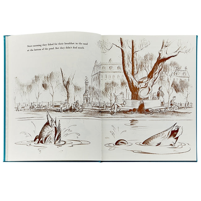Illustration of fish tails poking out of a pond in a park setting, with trees and a building in the background. Nearby, elegantly rendered mallards from the "Make Way For Ducklings, Leather" collection by Graphic Image glide gracefully on the water’s surface.