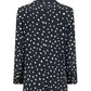 The Mariquita Everyday Blazer by Blaze Milano features black fabric with white irregular polka dots, shown from the back.