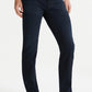 An individual in AG Jeans' Everett Denim, Bundled slim straight dark denim wash, paired with a white t-shirt and sneakers, stands against a plain white backdrop.