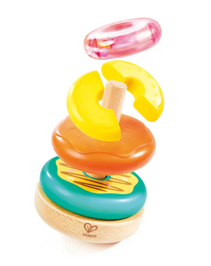 The Stacking Donut Toy by Hape features a wooden base with a central rod and vibrant plastic rings in yellow, orange, and pink, shown separated above the base. This colorful sensory toy is designed to promote fine motor skills and encourage cognitive growth through hands-on play.