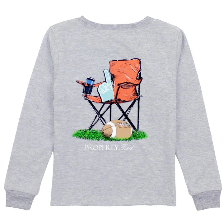 The Properly Tied Boys' Long Sleeved Tee is a gray shirt with hand-drawn graphics of an orange folding chair holding a foam finger and drink next to a football on grass, with "PROPERLY Tied" text below.