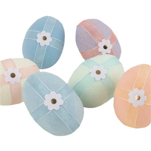 Meri Meri's Surprise Eggs, featuring six pastel-colored eggs with ribbons and paper flowers, are artfully arranged in a random pattern—ideal as charming party decorations or Easter basket surprises.