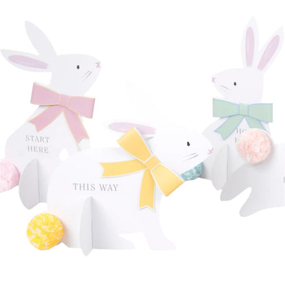 The Meri Meri Egg Hunt Kit includes three stylish bunny signs with pastel bows and pom-pom tails, featuring directional cues like "Start Here" and "This Way," perfect for adding a festive touch to your Easter celebration.