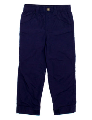 A pair of Boys' Mallard Pant by Properly Tied in navy blue, featuring an elastic waistband, side pockets, button closure, and folded cuffs. These lightweight children's pants are laid flat on a white background.
