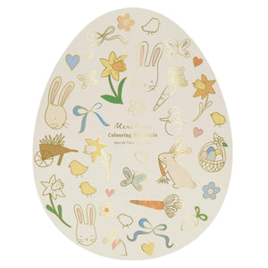 The Easter Placemats by Meri Meri feature an egg-shaped coloring mat filled with springtime icons such as bunnies, flowers, and carrots, decorated in pastel hues. It's the perfect Easter gift for creative fun.