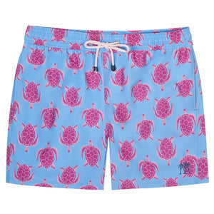 The Pink House Mustique Turtle Trunks are light blue quick-dry swim shorts featuring a playful pink sea turtle pattern, white drawstring, and a comfortable elastic waistband.