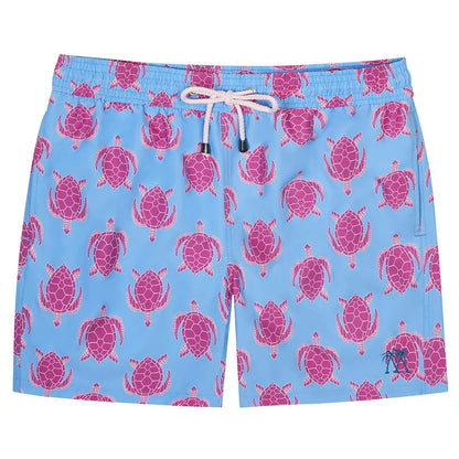 The Pink House Mustique Turtle Trunks are light blue quick-dry swim shorts featuring a playful pink sea turtle pattern, white drawstring, and a comfortable elastic waistband.
