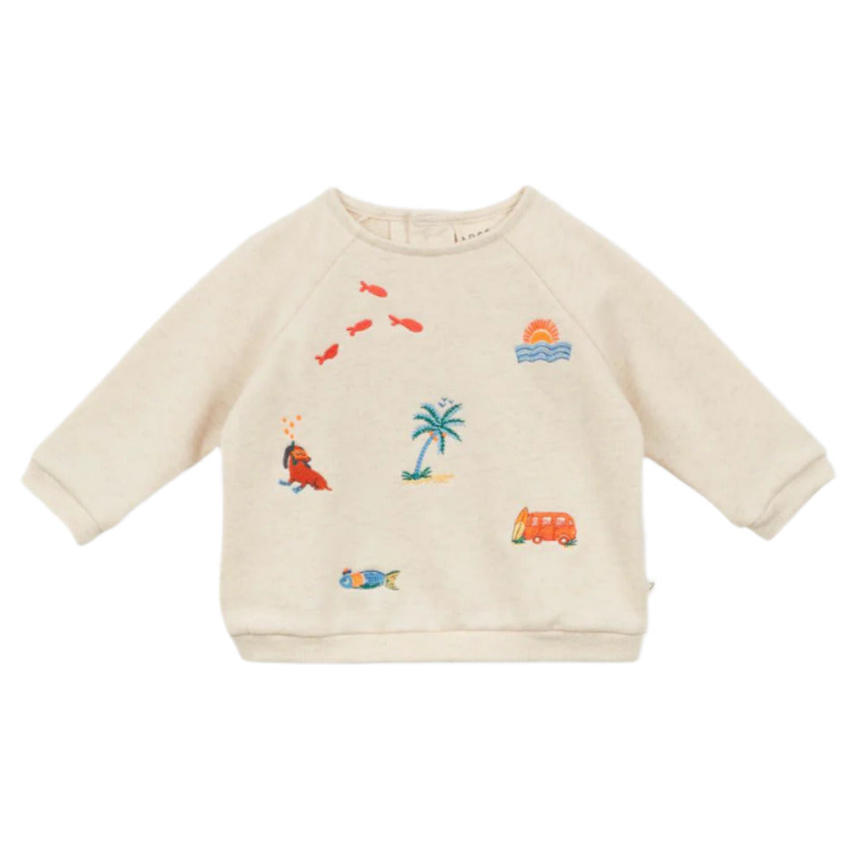 The Baby Faustin Sweatshirt by Arsene & Les Pipelettes is a relaxed, cream-colored children’s sweatshirt featuring colorful embroidered designs like a palm tree, fish, seal, van, sunrise, and a fish in water.