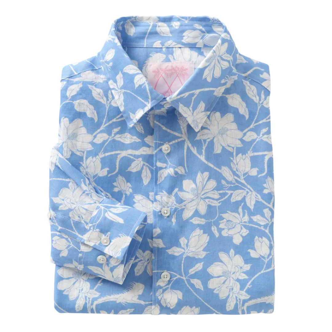 A folded Pink House Mustique Printed Linen Shirt in light blue with a white floral pattern, inspired by the relaxed elegance of Mustique, displayed on a plain white background.