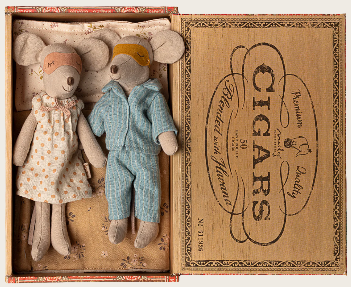 Mum and Dad in Cigarbox by Maileg features two fabric mice—dressed in pajamas and sleep masks—resting side by side in a cozy cigar box bed lined with a soft mattress and patterned bedding. The box lid is decorated with vintage-style “Cigars” text and graphics.