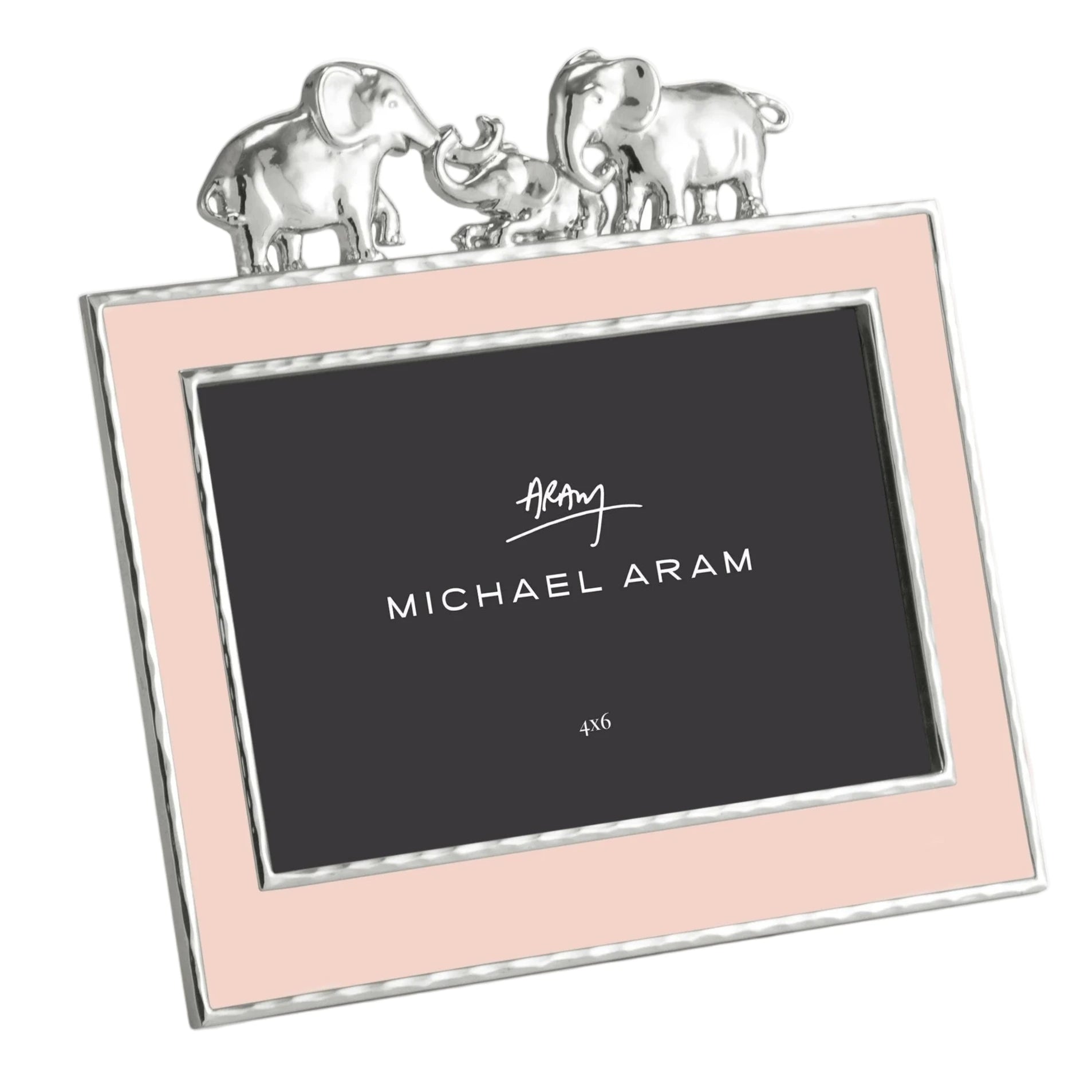 The Michael Aram Elephant Frame 4X6 - Pink features a pink border with silver trim and three silver elephants on top—perfect for displaying cherished memories in style. The center displays “Michael Aram” and “4x6.”.