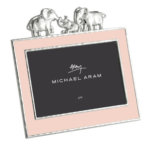 The Michael Aram Elephant Frame 4X6 - Pink features a pink border with silver trim and three silver elephants on top—perfect for displaying cherished memories in style. The center displays “Michael Aram” and “4x6.”.