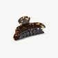 The Machete Midi Heirloom Claw, crafted from luxurious Italian acetate in a tortoiseshell pattern and featuring curved edges with double-walled interlocking teeth, is displayed against a plain light background.