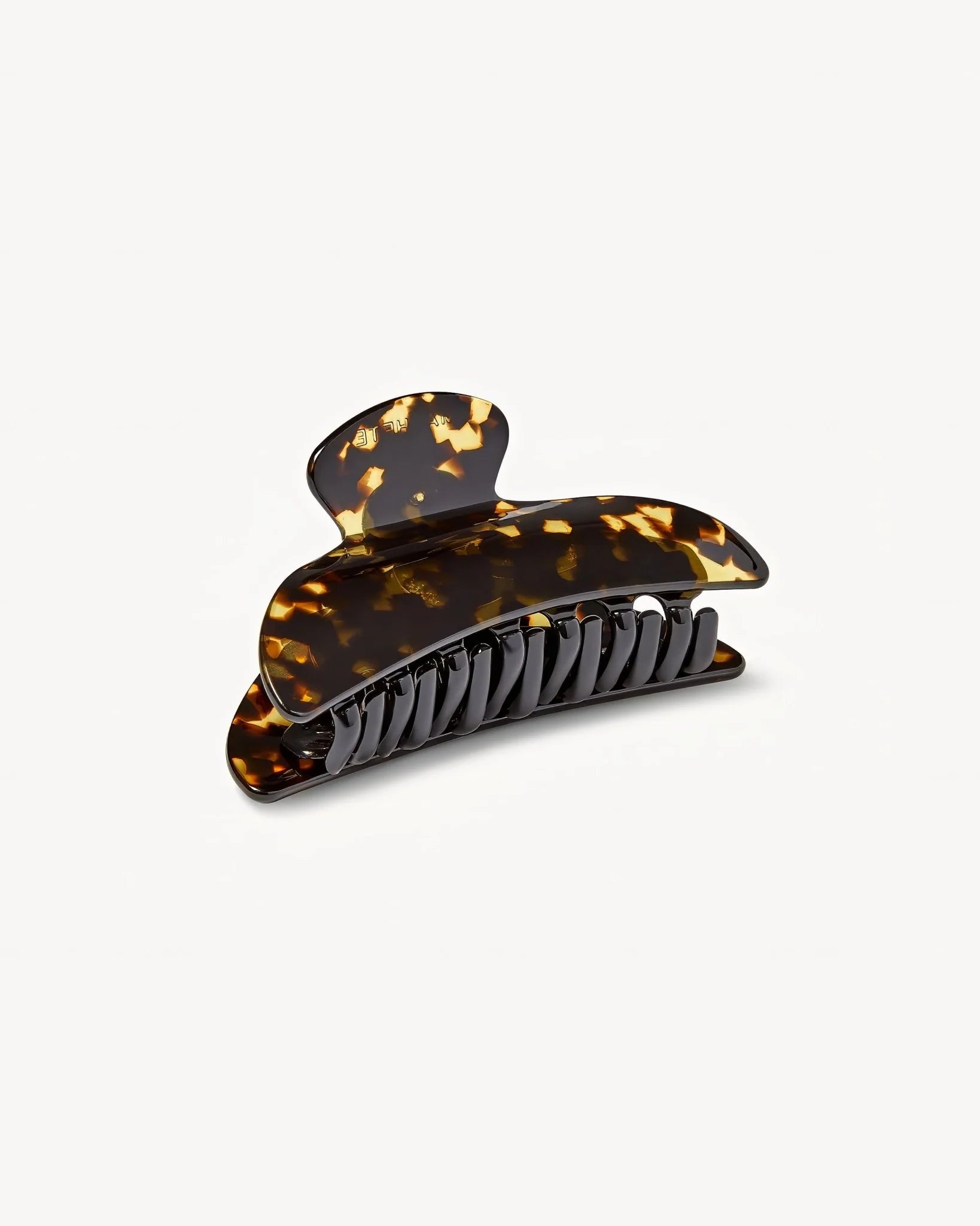 The Machete Midi Heirloom Claw, crafted from luxurious Italian acetate in a tortoiseshell pattern and featuring curved edges with double-walled interlocking teeth, is displayed against a plain light background.