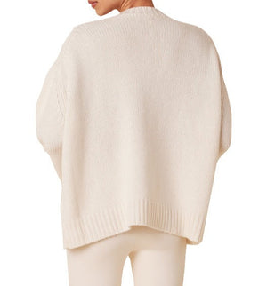 Person wearing a light-colored, oversized Sablyn Mimi Crewneck Sweater and matching soft cashmere pants, seen from the back.