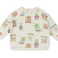 The Baby Sweatshirt by Arsene & Les Pipelettes is a cream-colored, long-sleeve piece made from organic cotton, adorned with vibrant illustrations of palm trees, carts, and the "HAY FRIOS" text playfully scattered across its soft fabric.