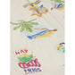The Baby Mini Coco Jumpsuit by Arsene & Les Pipelettes features a beige fabric adorned with vibrant illustrations of palm trees, a beach scene, and a toucan, along with the playful phrase "HAY COCOS FRIOS" in bold red and blue lettering. This cozy romper is perfect for sunny days and brings a cheerful touch to your little one's wardrobe.