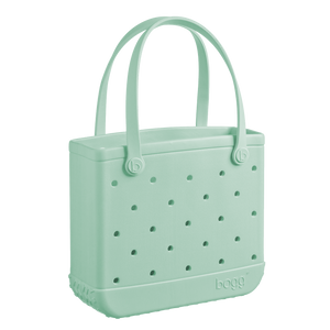 The Baby Bogg Bag by Bogg Bags is a light green, rectangular tote featuring perforated holes, dual handles, and "bogg" embossed near the base—a washable bag that’s stylish and practical.