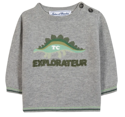 The Tartine et Chocolat Baby Boys’ and Toddler Knitted Sweater is crafted from 100% cotton in gray and features a playful green dinosaur graphic with the phrase “TC EXPLORATEUR” on the front, two buttons on the left shoulder, and green trim on the cuffs and hem.