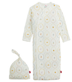 The Magnetic Me Baby Nursery Magic Cream Gown & Hat Set showcases a whimsical print of animals and hot air balloons on a soft cream background, displayed flat. Perfect for newborn comfort, it’s thoughtfully designed for easy diaper changes.