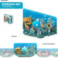 A box of Halftoys Ocean Friends diorama set toys with an underwater theme is shown. The assembled Halftoys Ocean Friends diorama features colorful aquatic creatures and can be linked with other dioramas.