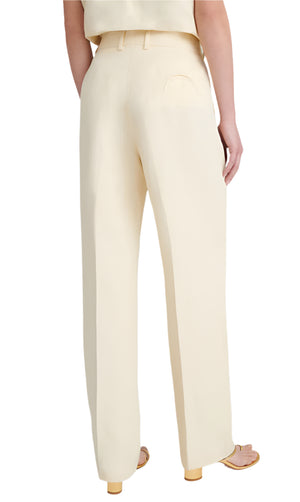 Someone is seen from behind wearing Blaze Milano's BZM Savannah Fox Pants, which have a high-rise design in a linen-silk blend, paired with heeled sandals.