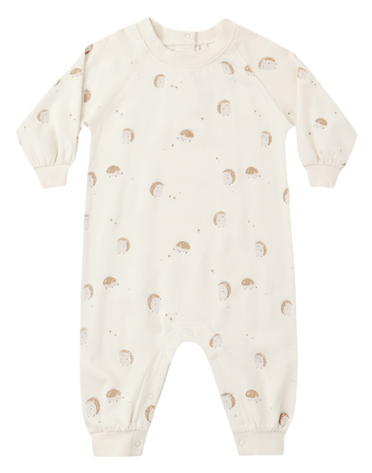 The Rylee & Cru Baby Raglan Jumpsuit is a cream-colored long sleeve romper with legs, adorned with a charming pattern of small hedgehogs and dots. Made from soft French terry, this adorable jumpsuit provides cozy comfort for your little one, making it perfect for everyday wear.