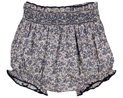 The Kidiwi Baby Girls' Myrtille Smocked Bloomer features a navy blue floral print, 100% cotton fabric, an elastic waistband, and delicate smocking at the top.