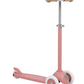 The Banwood Eco Scooter, part of the Eco Collection, is a pink three-wheeled scooter with beige handlebars and white recycled plastic wheels, shown on a white background.