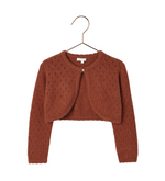 The Noralee Baby Girls' & Girls' Bolero Sweater in rust features a heart pointelle knit, long sleeves, a cropped fit, and a single button closure at the neckline. Displayed on a hanger.