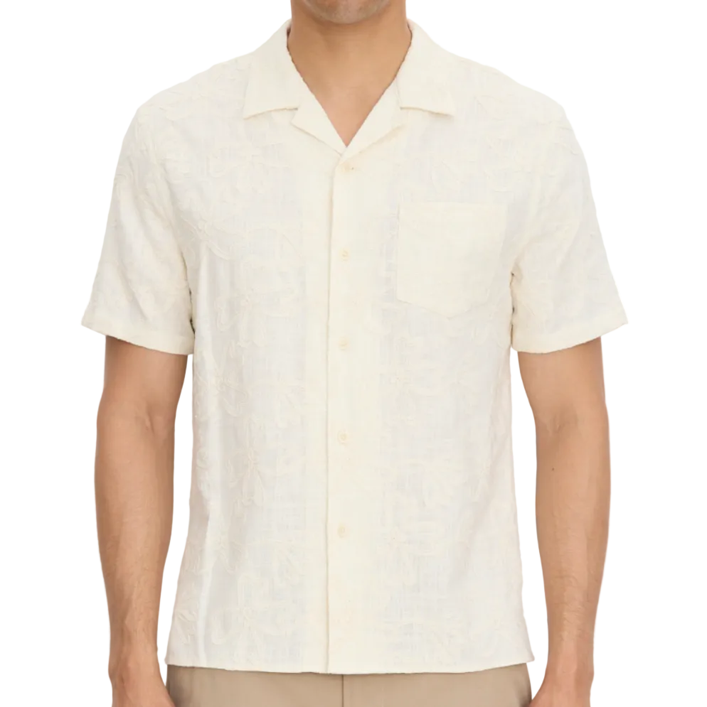 A man wears the vince Embroidered Floral Shortsleeve Cabana Shirt, featuring a front pocket, against a plain background.