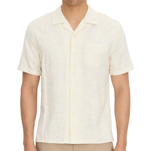 A man wears the vince Embroidered Floral Shortsleeve Cabana Shirt, featuring a front pocket, against a plain background.