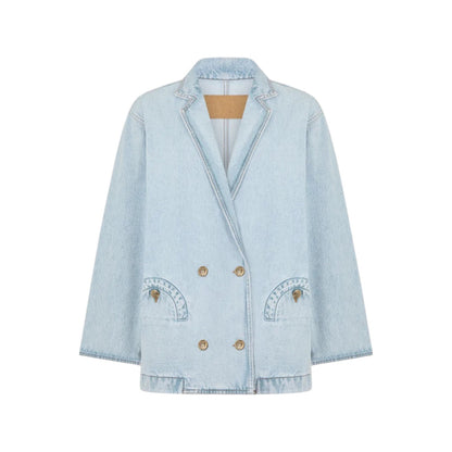 The Nariida Cory Jacket by Blaze Milano is a light blue denim, oversized double-breasted blazer with notched lapels, two front pockets, and metal buttons, shown on a plain white background.