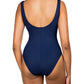 A woman is standing with her back to the camera, wearing a dark blue Karla Colletto Basics Twist Underwire Tank swimsuit with a scoop back design that perfectly supports the female form.