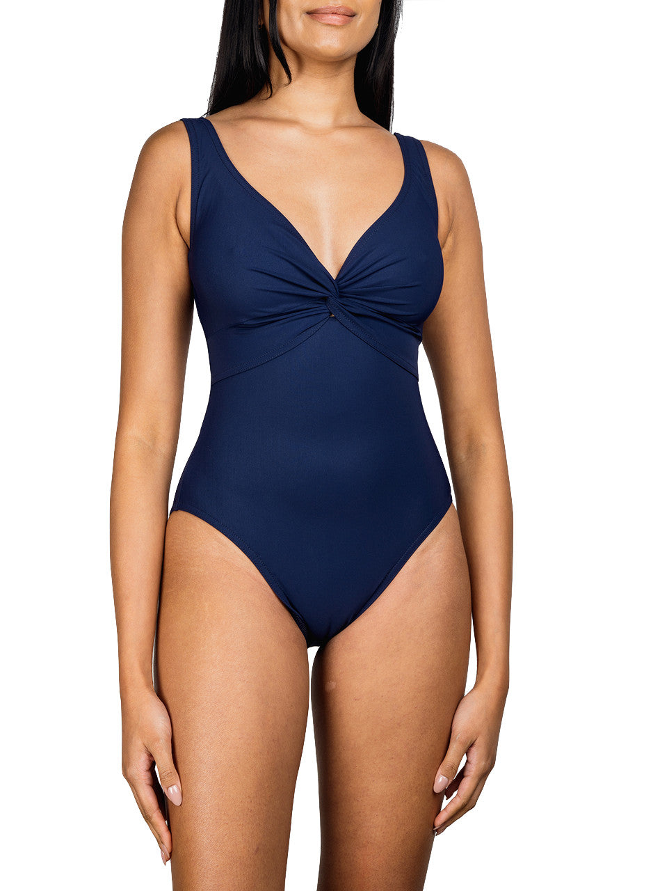 A woman wearing a Karla Colletto Basics Twist Underwire Tank swimsuit designed to support the female form, featuring a v-neckline and gathered detail at the bust.