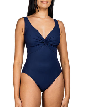 A woman wearing a Karla Colletto Basics Twist Underwire Tank swimsuit designed to support the female form, featuring a v-neckline and gathered detail at the bust.