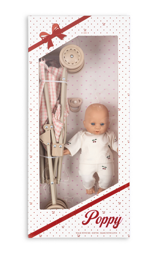 A Konges Slojd Poppy Doll Stroller Set featuring a doll in white cherry-print pajamas and a folded toy stroller inside a gift box with a heart-patterned background.