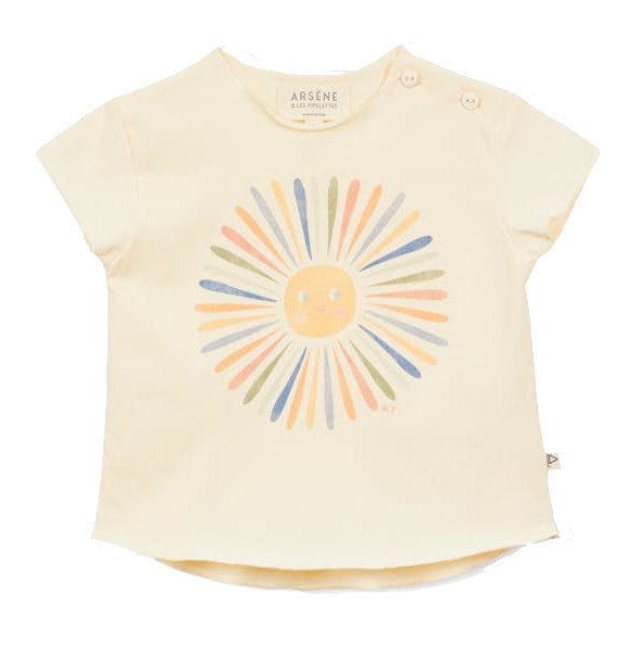 The Arsene & Les Pipelettes Baby Girls' Fleur T-Shirt is a cream-colored children's top made from soft organic cotton, featuring a pastel sun graphic and two buttons on the left shoulder.
