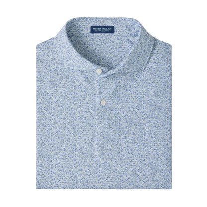 A folded Peter Millar Limoncello Performance Jersey Polo in a blue and white floral pattern, featuring a collared neckline with two buttons and four-way stretch for optimal comfort, displayed on a plain white background.