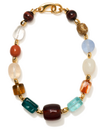 The Acrobat Necklace by Lizzie Fortunato features multicolored resin round and rectangular beads, gold-plated brass spacer beads, and a gold clasp, displayed in a circular arrangement on a white background.