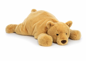 A plush teddy bear lies flat on its stomach with its head resting on its front paws against a white background. This adorable stuffed bear, lovingly named Jellycat Harvey Bear, exudes comfort and charm.