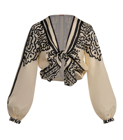 Gentle Burn Top in a cream-colored long-sleeve linen, featuring a cropped silhouette, a tie front, and black abstract patterns on the collar, cuffs, and chest.