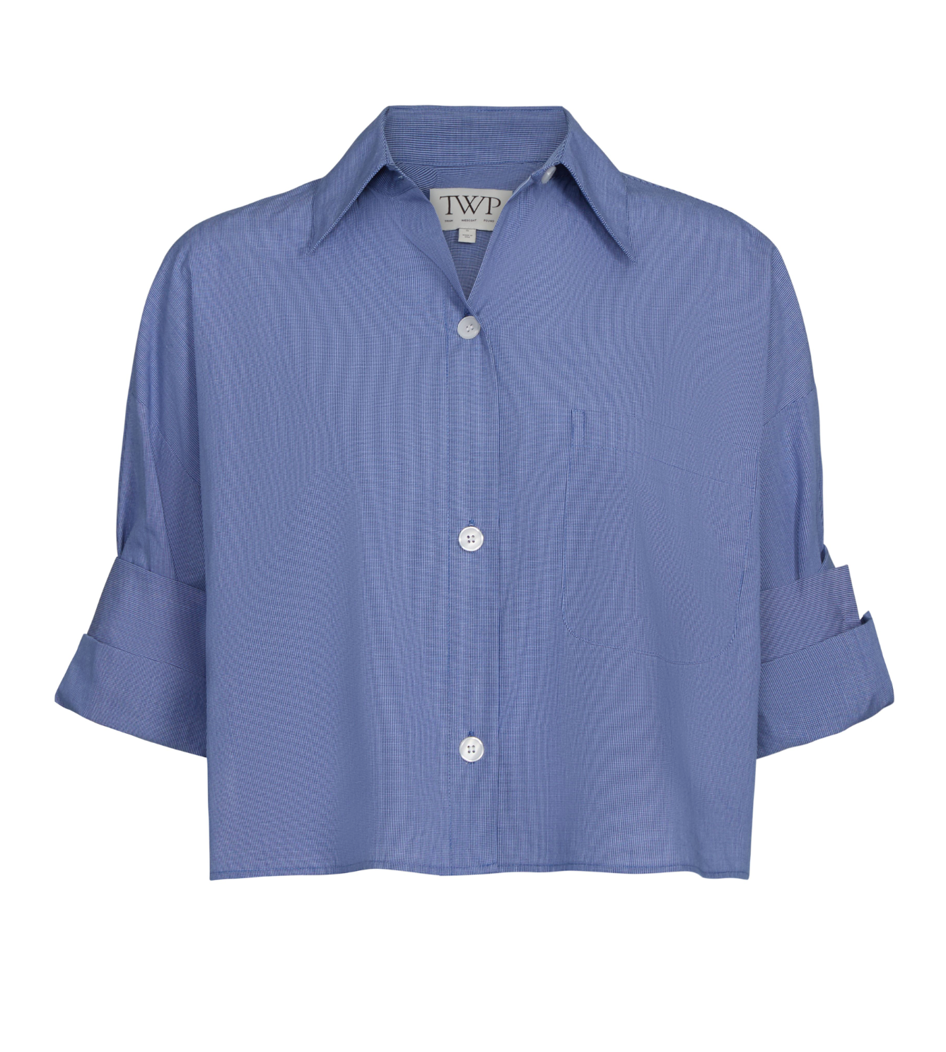 The TWP Next Ex Stripe Shirt is a cropped blue button-down with a boxy silhouette, short sleeves, collar, and front chest pocket.
