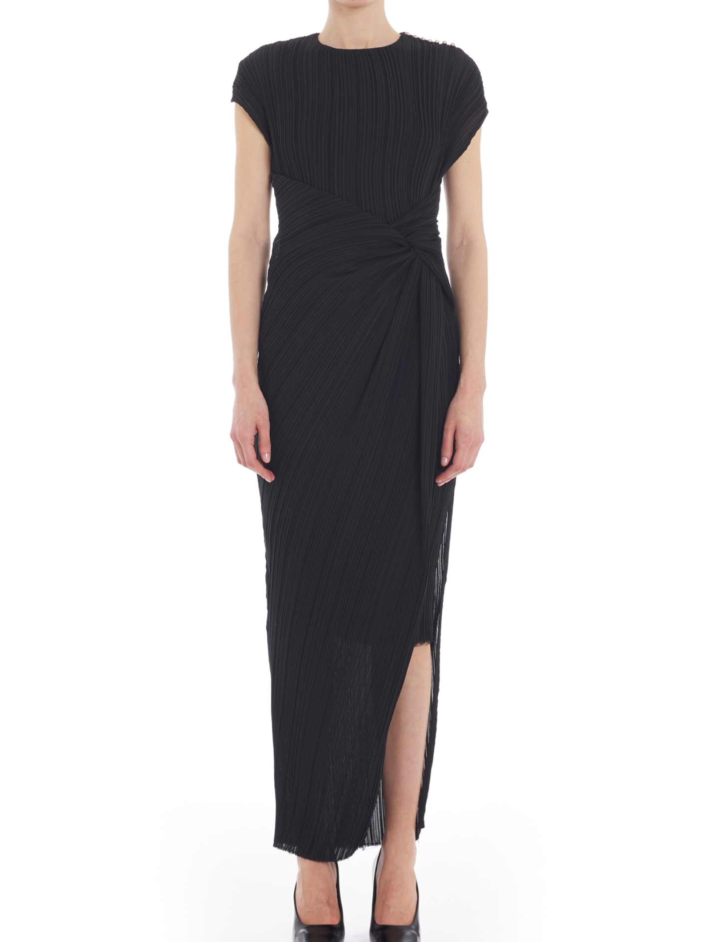A person is wearing the Lanvin Asymmetrical Long Pleated Dress, a black, short-sleeved, ankle-length piece with pleated fabric, a draped waist with side knot detail, and a front slit, standing against a white background.
