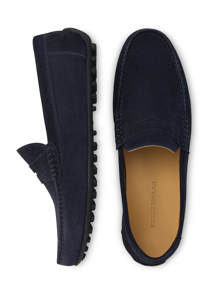 Top view of a pair of navy blue Peter Millar Suffolk Suede Driver loafers with black pebbled rubber outsoles.